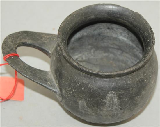 An Etruscan Bucchero ware single handled cup, c. 6th century BC, 9cm, repaired